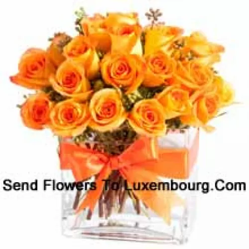 25 Orange Roses With Some Ferns In A Glass Vase