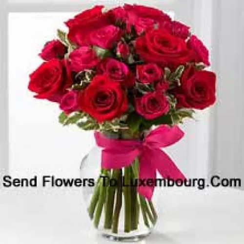 19 Red Roses With Seasonal Fillers In A Glass Vase Decorated With A Pink Bow
